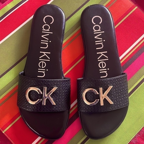 Brand New Calvin Klein Black Large Strap Sandals Flats w/ Gold Tone Metal Logo - Picture 2 of 12